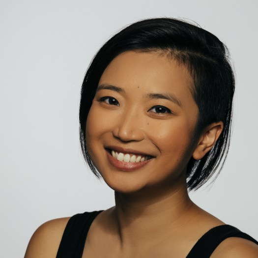 Krystle Piamonte, a young Asian woman with short dark hair and a black tank top smiling at the camera
